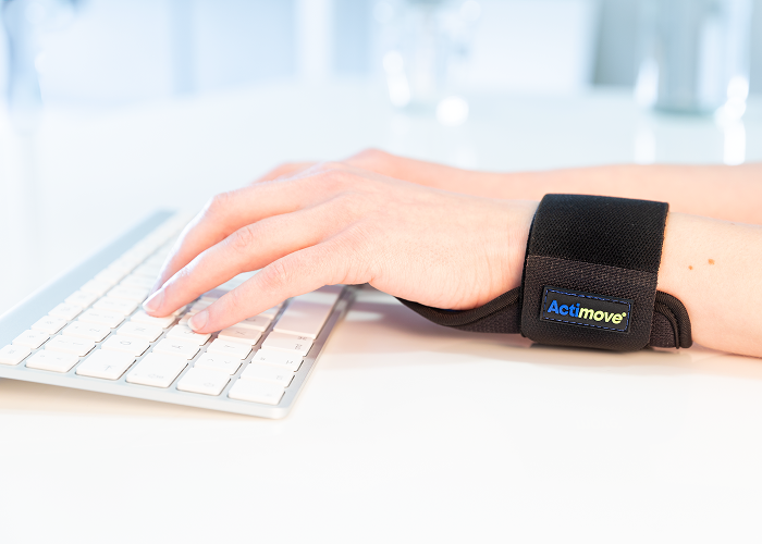 Persona utilizando la muñequera para tendinitis Actimove Sports Edition en el día a día. Persona utilizando la muñequera para tendinitis Actimove Sports Edition en el día a día.